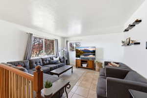 Living area featuring light tile patterned floors and a textured ceiling