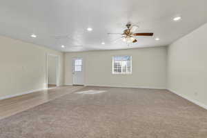 Empty room featuring light carpet, a ceiling fan, and recessed lighting