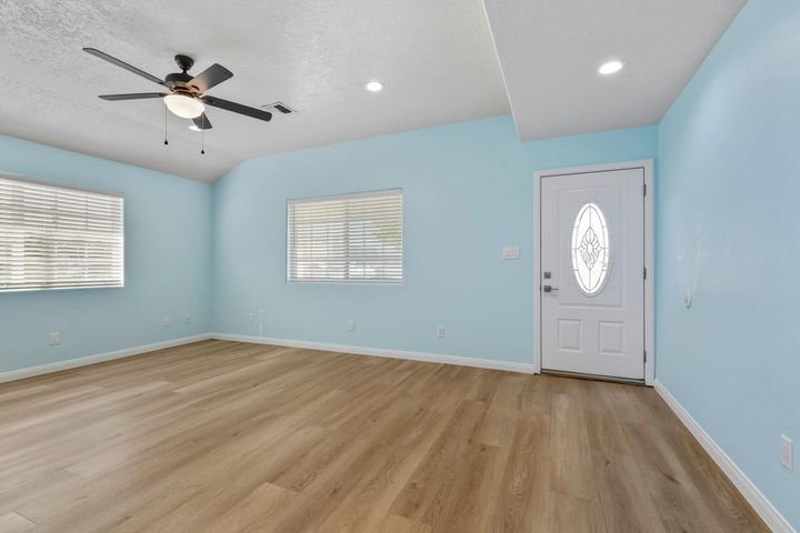 Foyer with ceiling fan, light wood-style floors, plenty of natural light, and a textured ceiling