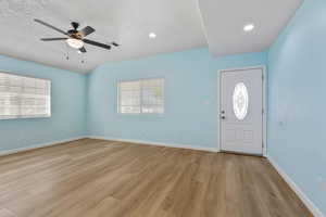 Foyer with ceiling fan, light wood-style floors, plenty of natural light, and a textured ceiling