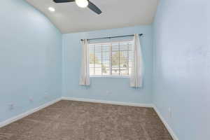 Unfurnished room featuring dark colored carpet, lofted ceiling, ceiling fan, and recessed lighting