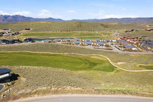 Aerial perspective of suburban area featuring a mountainous background and a golf course
