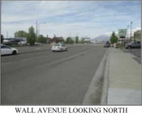 View of asphalt street featuring street lighting and sidewalks
