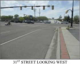 View of asphalt road with traffic lights and sidewalks