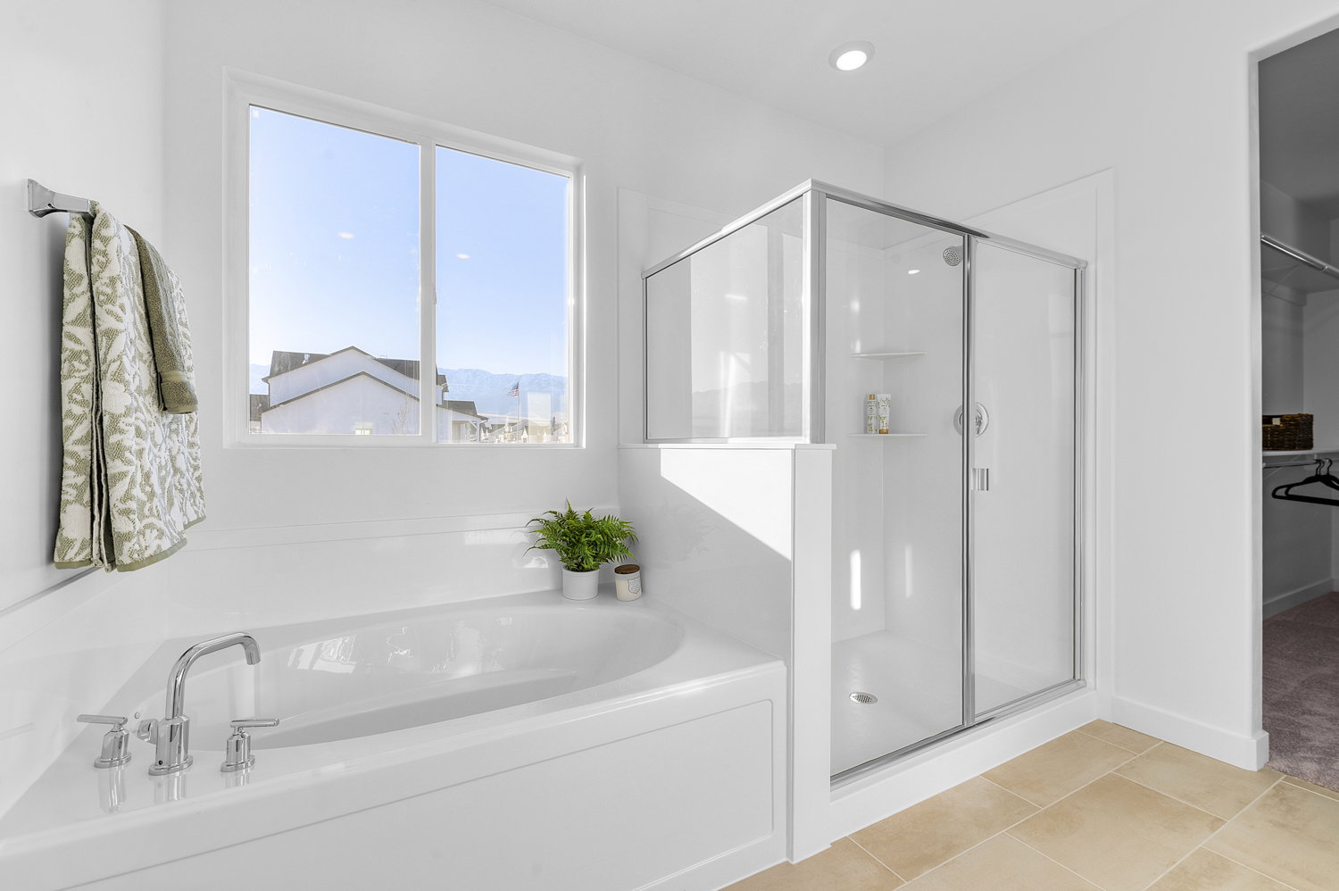 Bathroom featuring a shower stall, a garden tub, a walk in closet, and light tile patterned floors