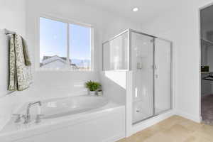 Bathroom featuring a shower stall, a garden tub, a walk in closet, and light tile patterned floors