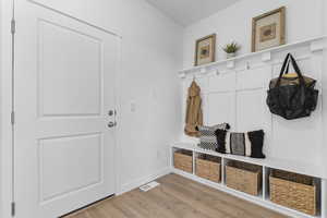 Mudroom with light wood-type flooring and baseboards