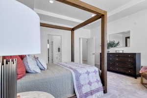 Bedroom with light carpet and connected bathroom