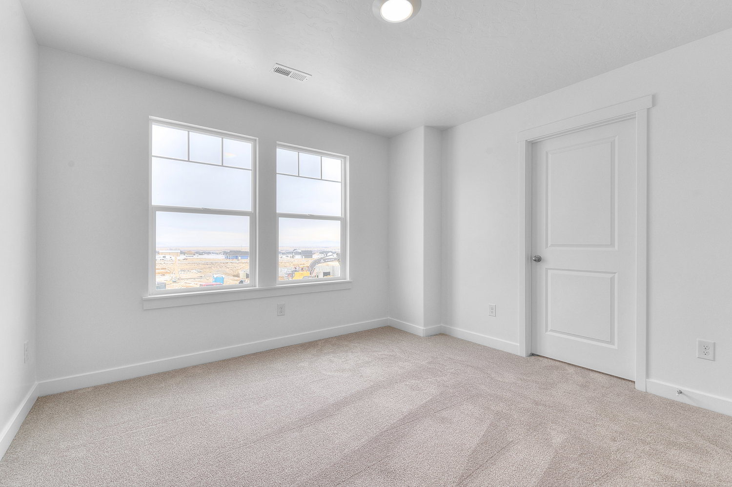 Spare room with baseboards and light colored carpet