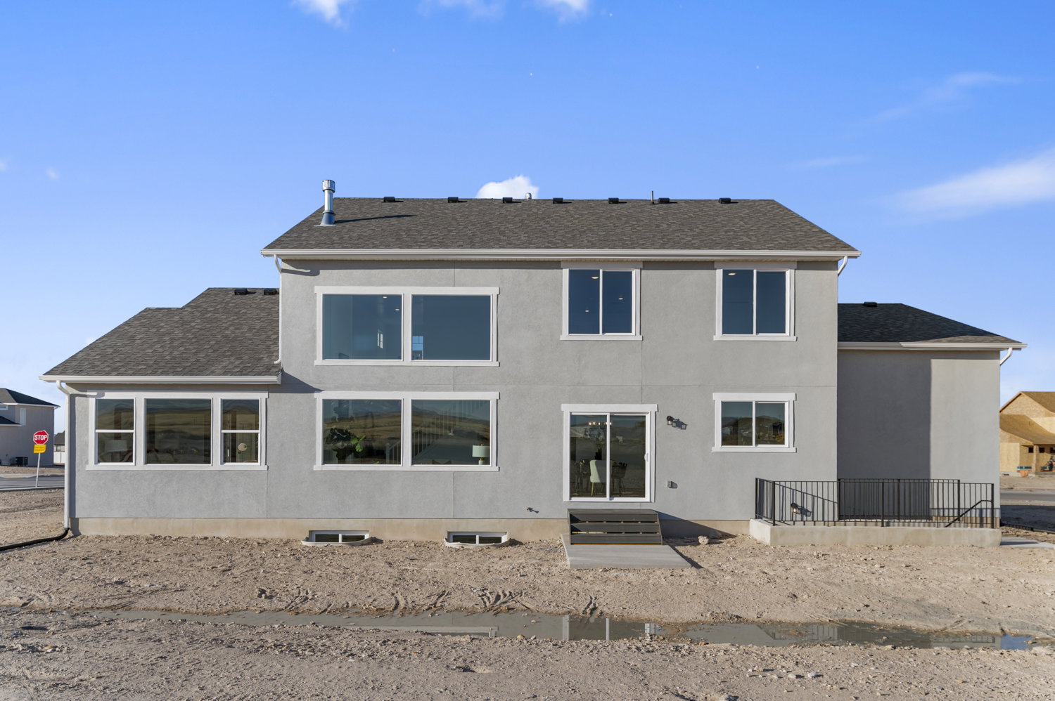 Rear view of house with roof with shingles and stucco siding