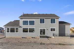 Rear view of house with roof with shingles and stucco siding
