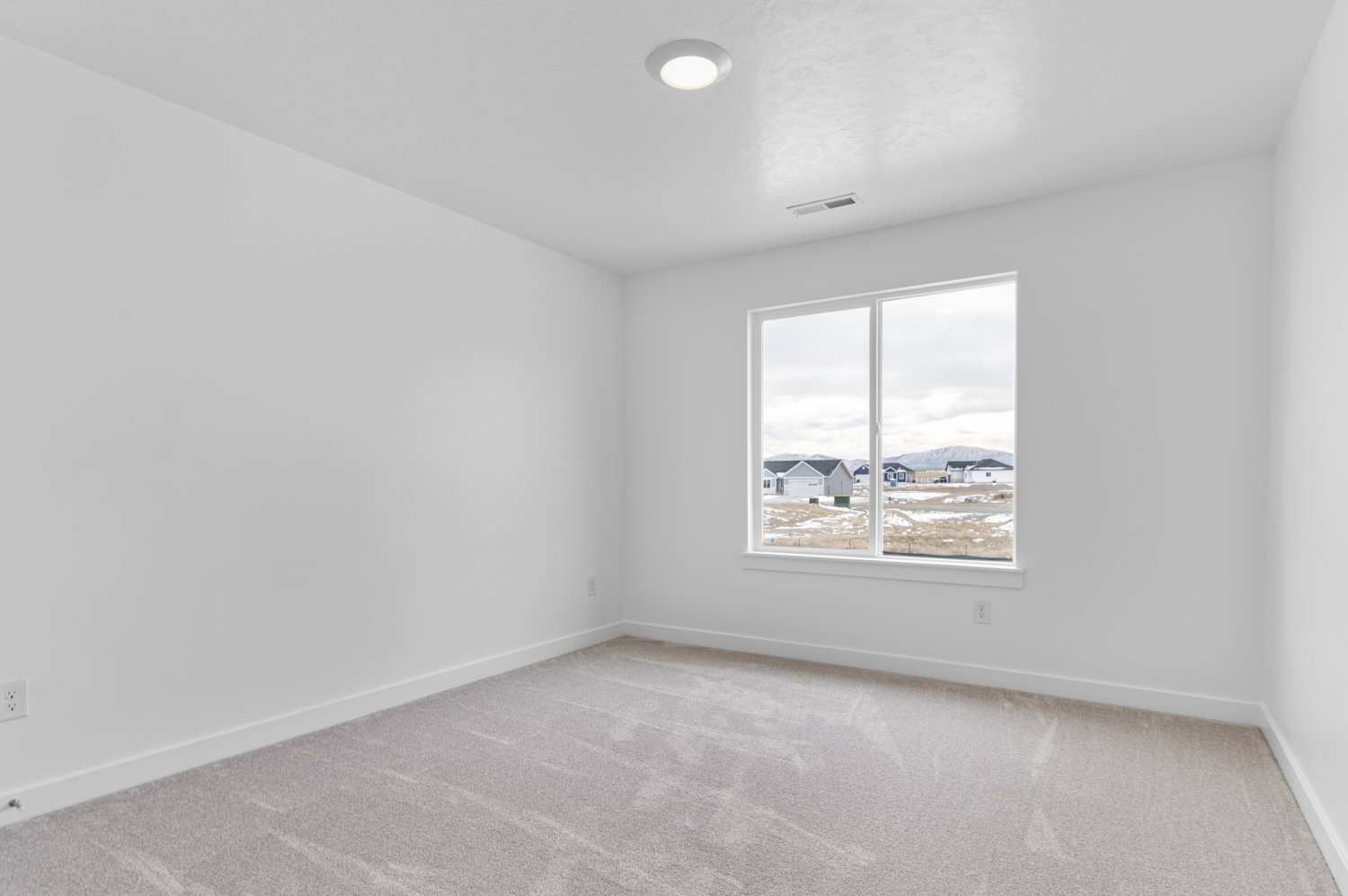 Empty room with light carpet and baseboards