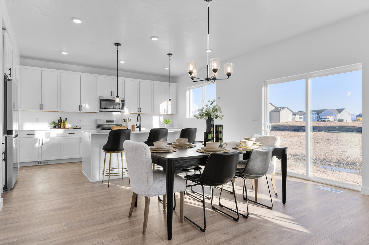 Dining room with light wood-style floors and hanging lights