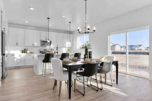 Dining room with light wood-style floors and hanging lights
