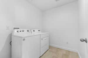 Laundry room featuring separate washer and dryer and vaulted ceiling