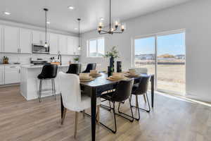 Dining room featuring light wood-type flooring and a chandelier