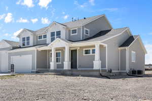 Craftsman house with a porch, a shingled roof, and driveway