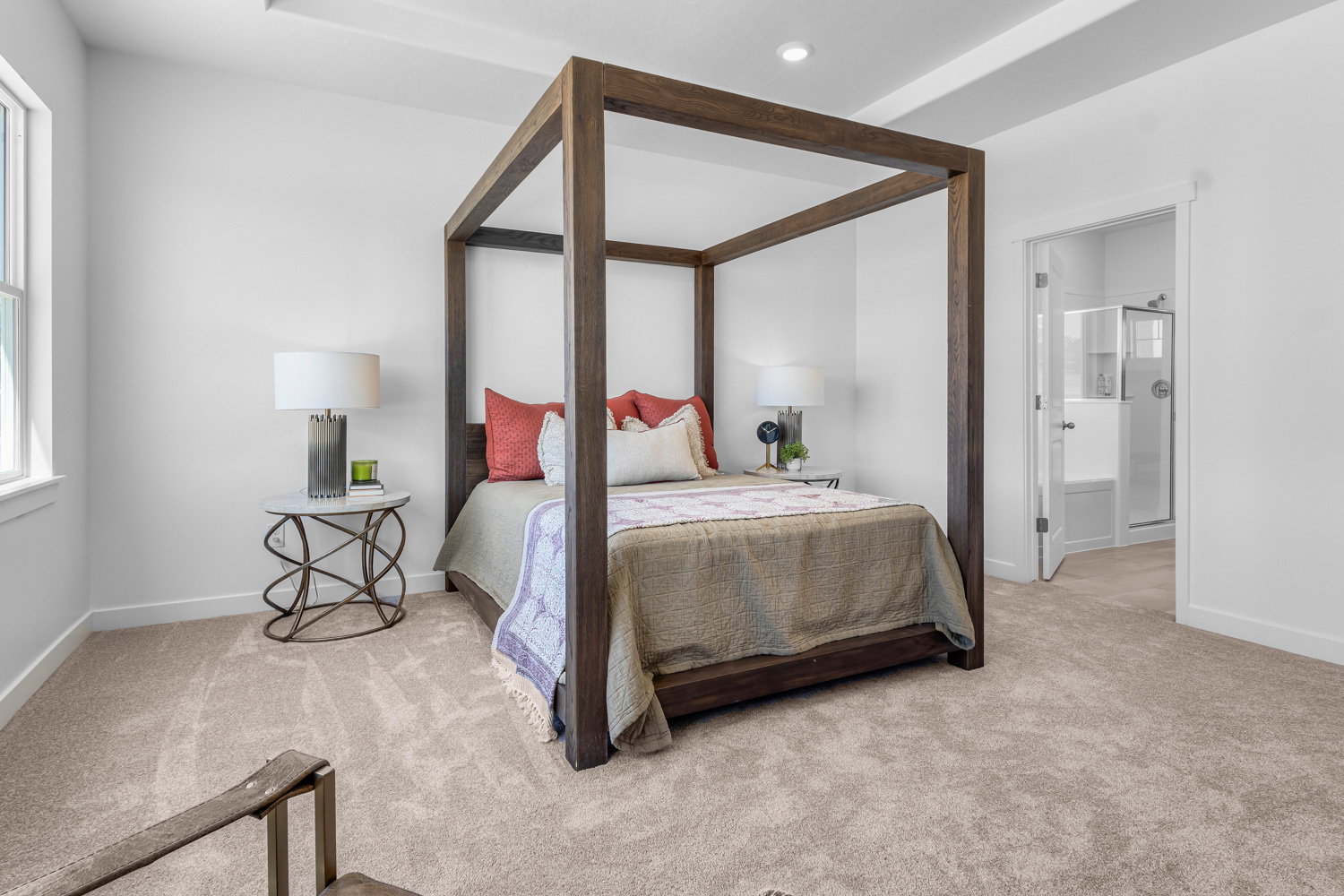 Bedroom with light carpet, ensuite bath, and multiple windows