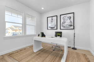 Office space featuring light wood-style floors and recessed lighting