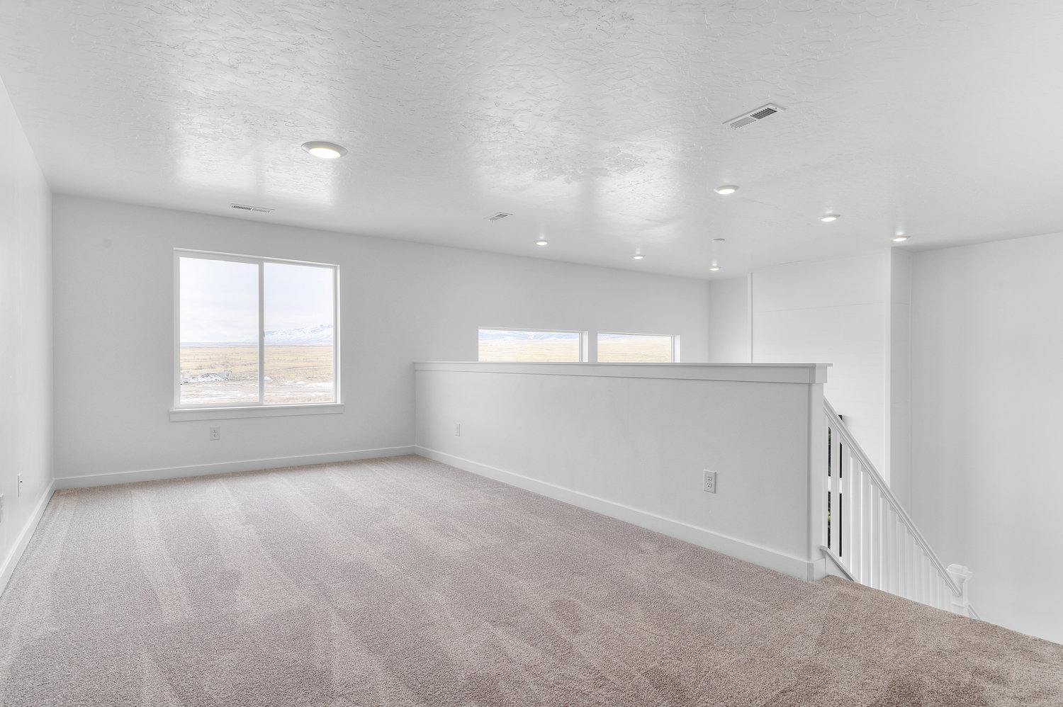 Empty room with carpet flooring and a textured ceiling