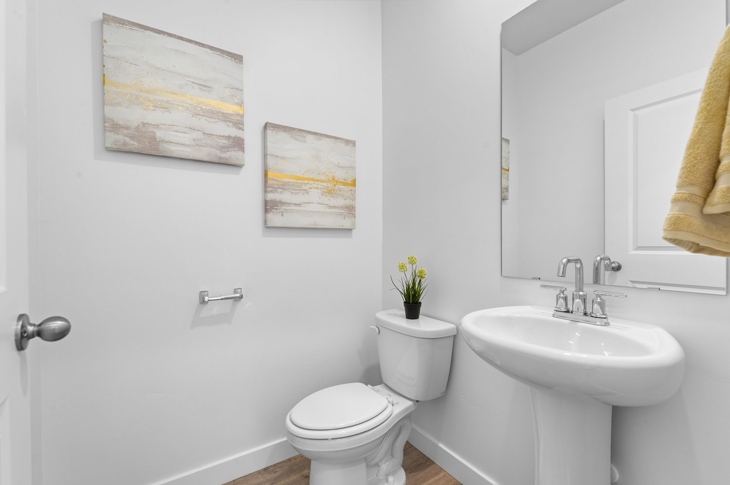 Half bath with toilet and wood finished floors