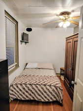Bedroom with hardwood / wood-style floors and a ceiling fan
