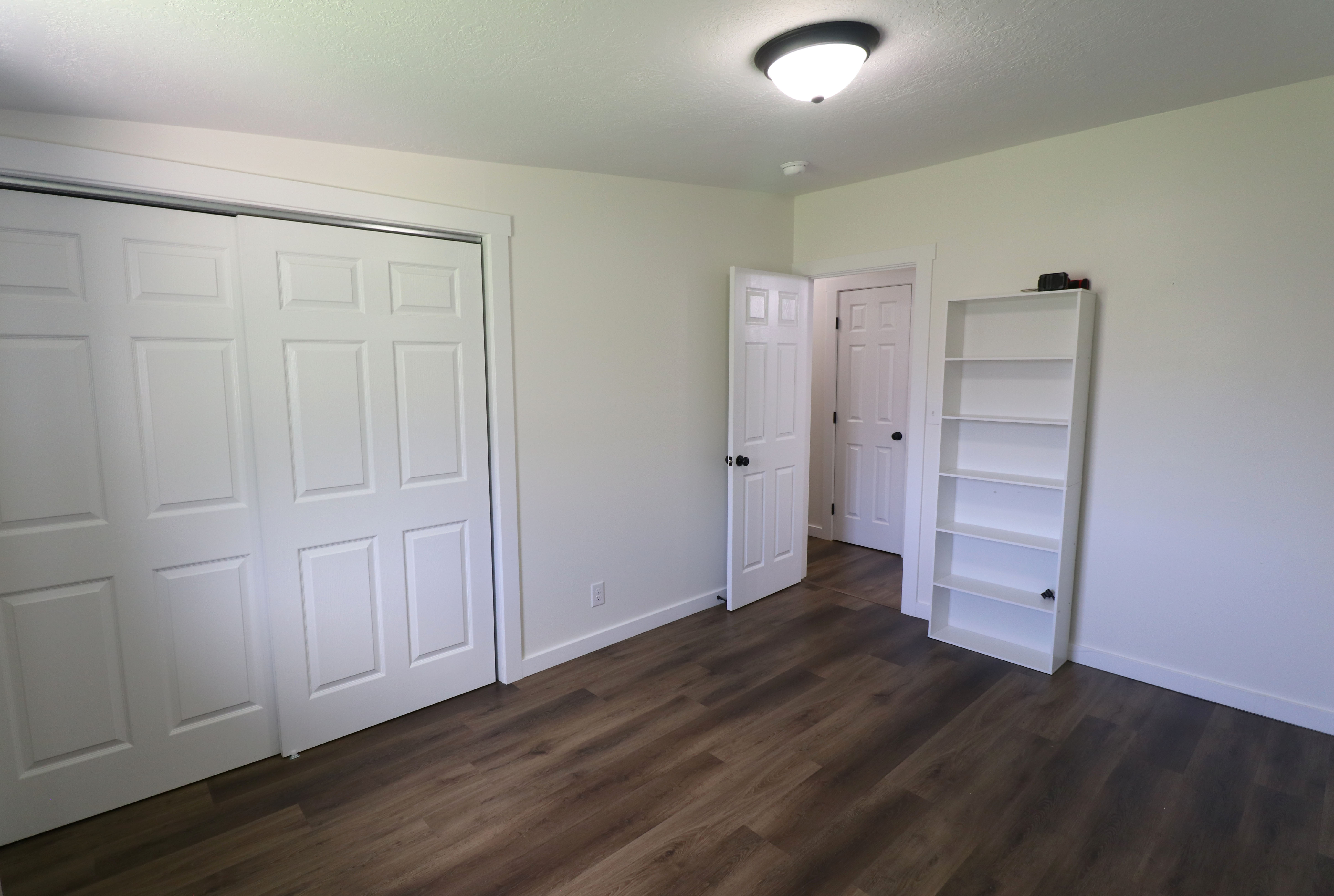 Unfurnished bedroom featuring a closet, dark wood-style flooring, and a textured ceiling