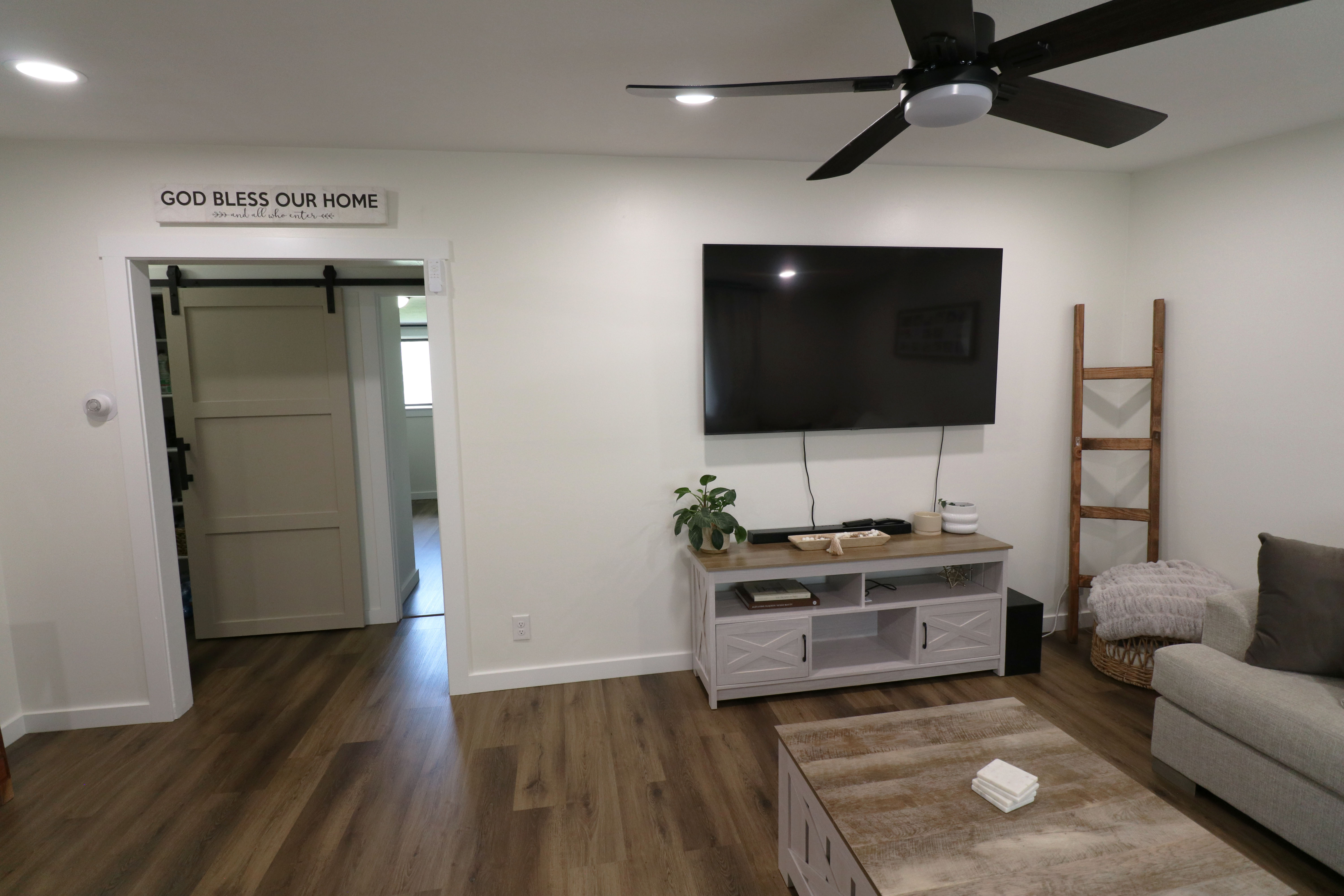 Living area featuring a barn door, dark wood-type flooring, a ceiling fan, and recessed lighting
