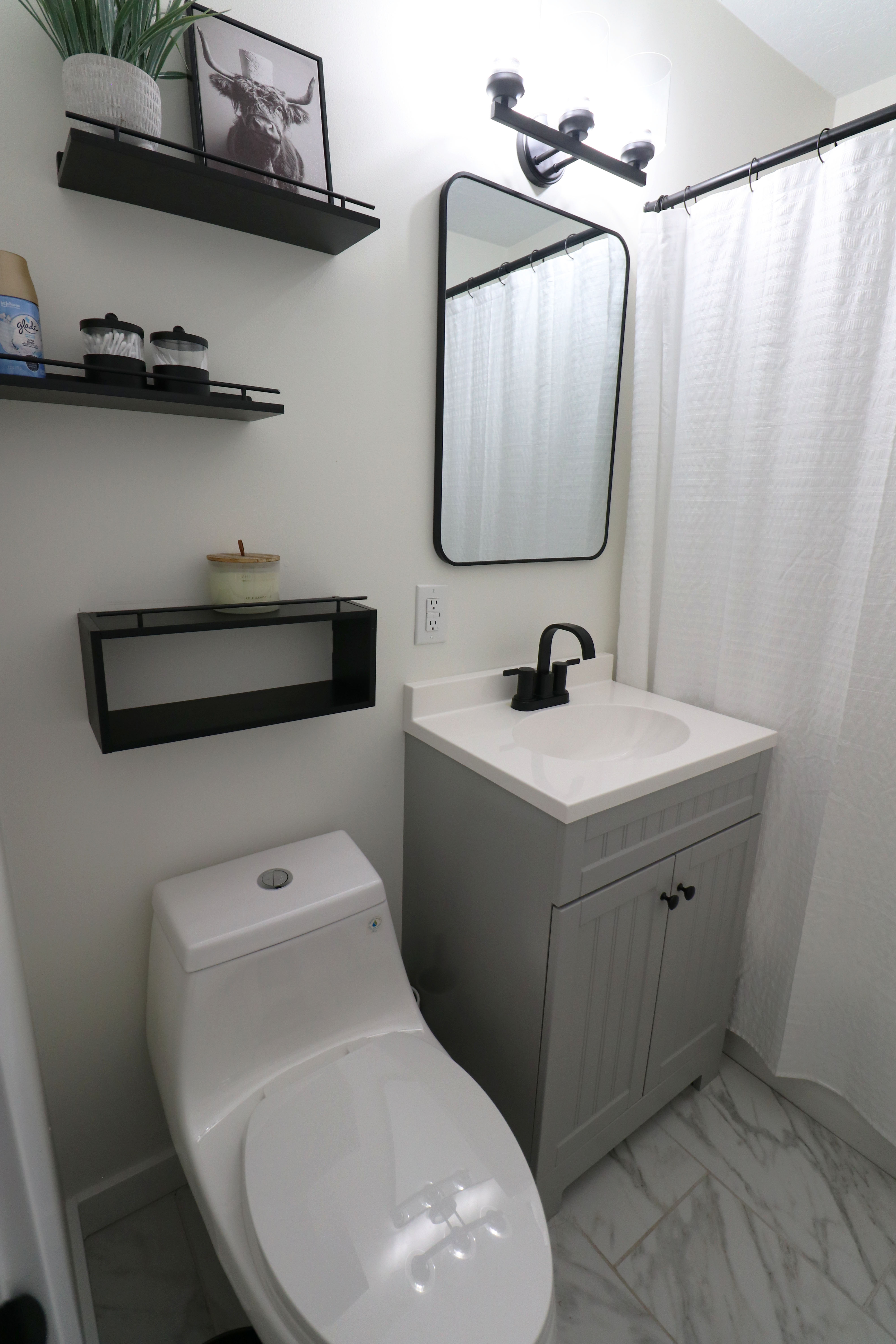 Bathroom featuring vanity, light marble finish floors, and a shower with shower curtain
