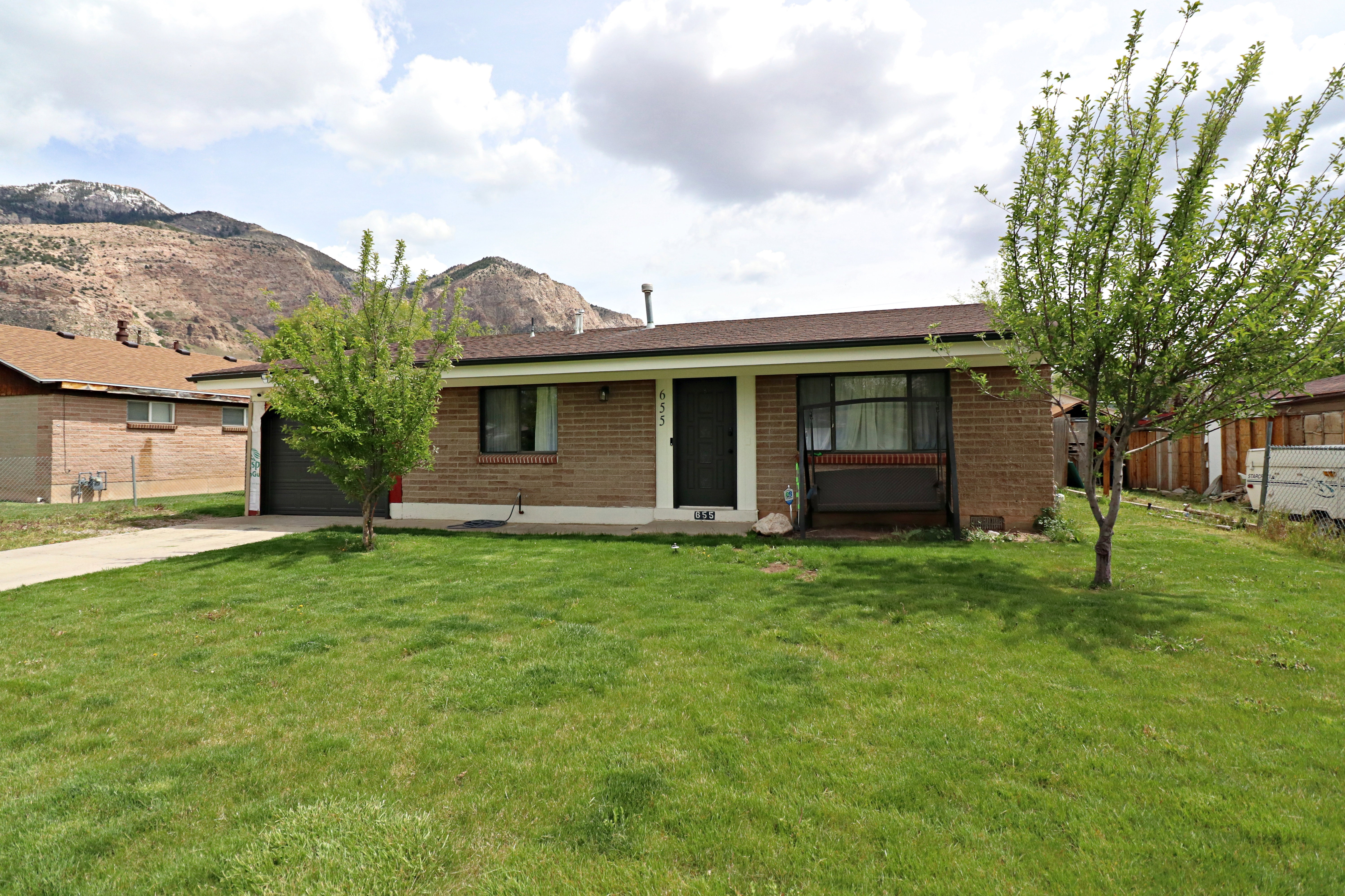 Ranch-style home with brick siding, driveway, an attached garage, and a mountain view