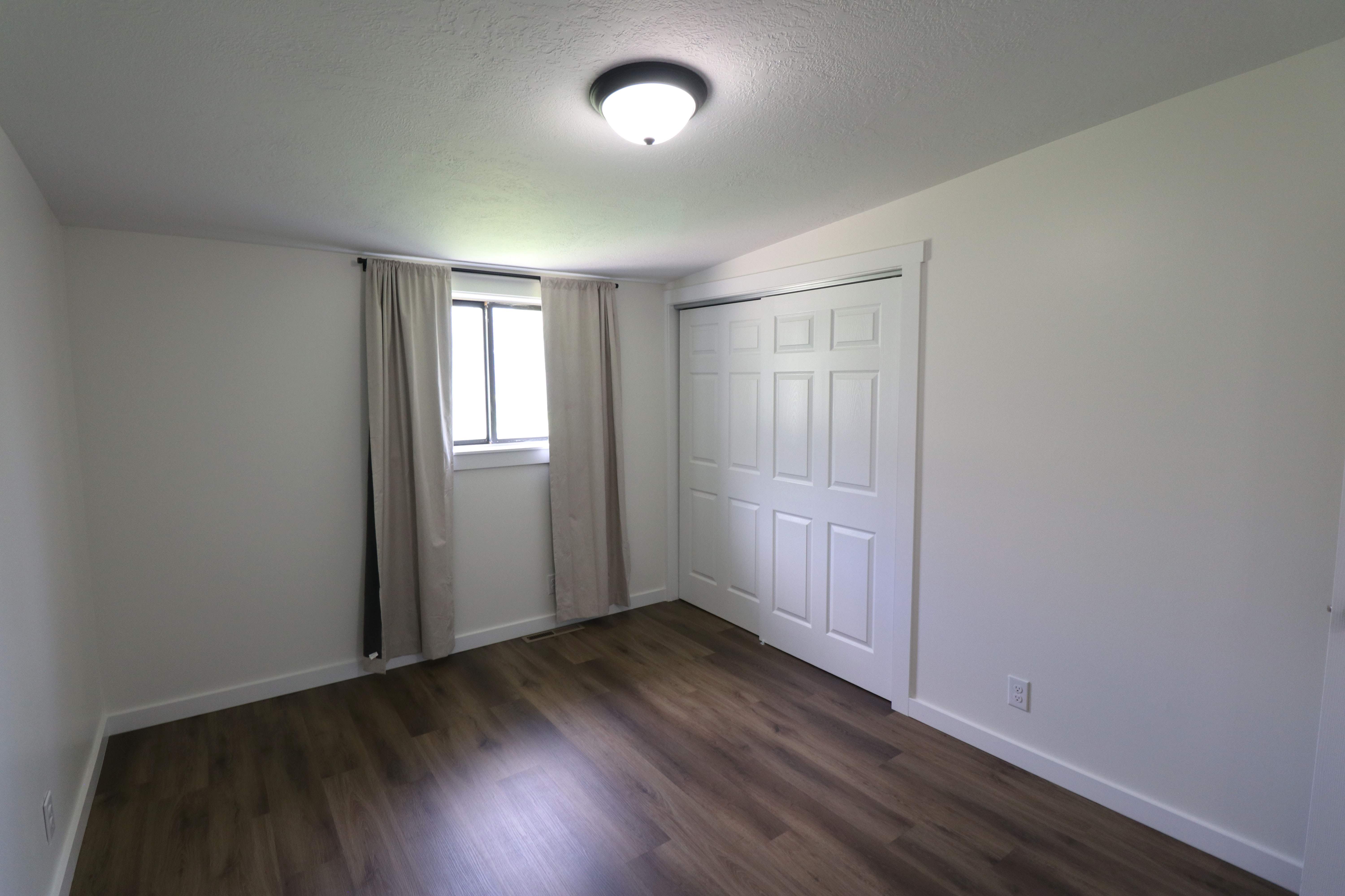 Unfurnished bedroom with a closet and dark wood-type flooring