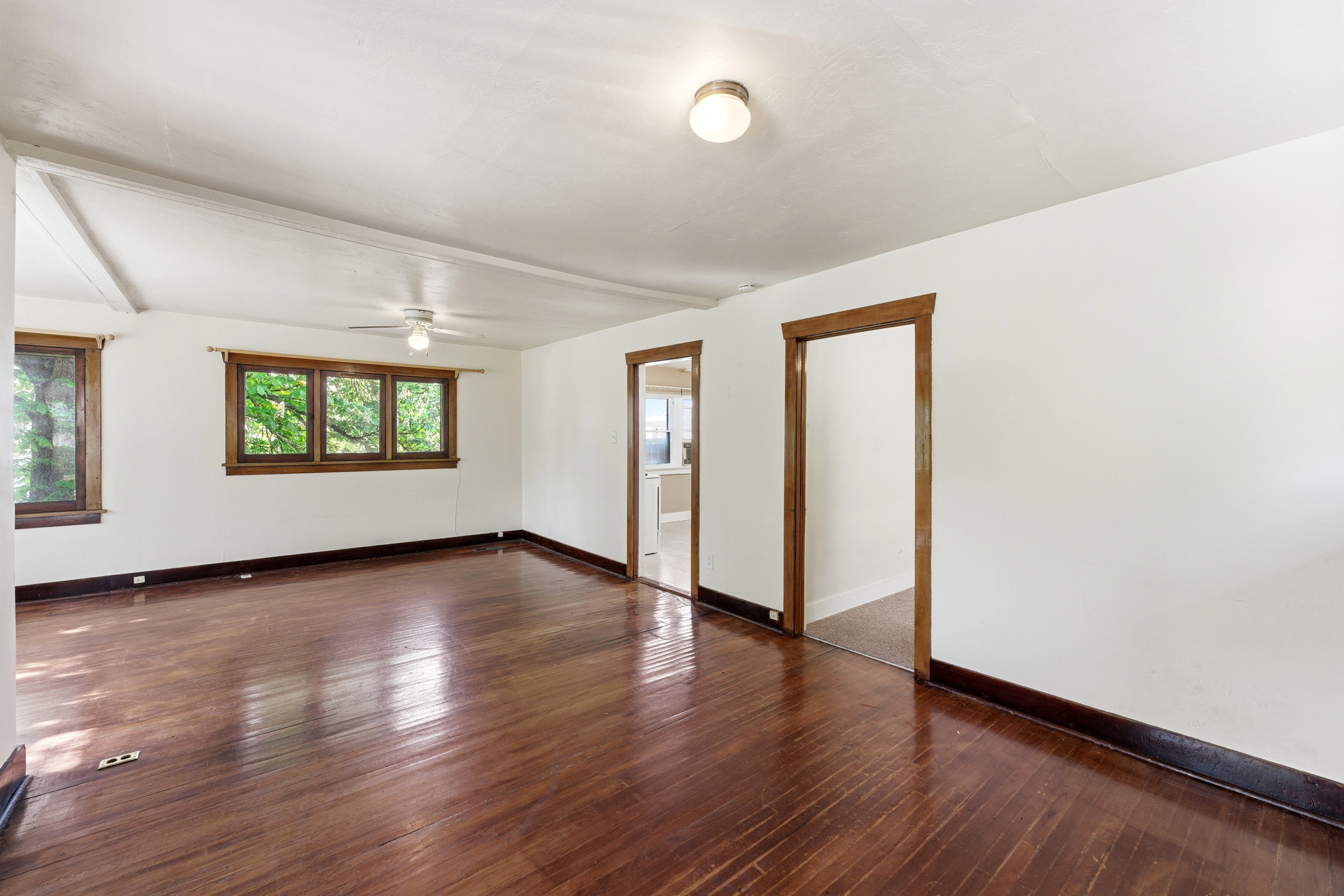 Empty room featuring dark wood-style flooring and ceiling fan