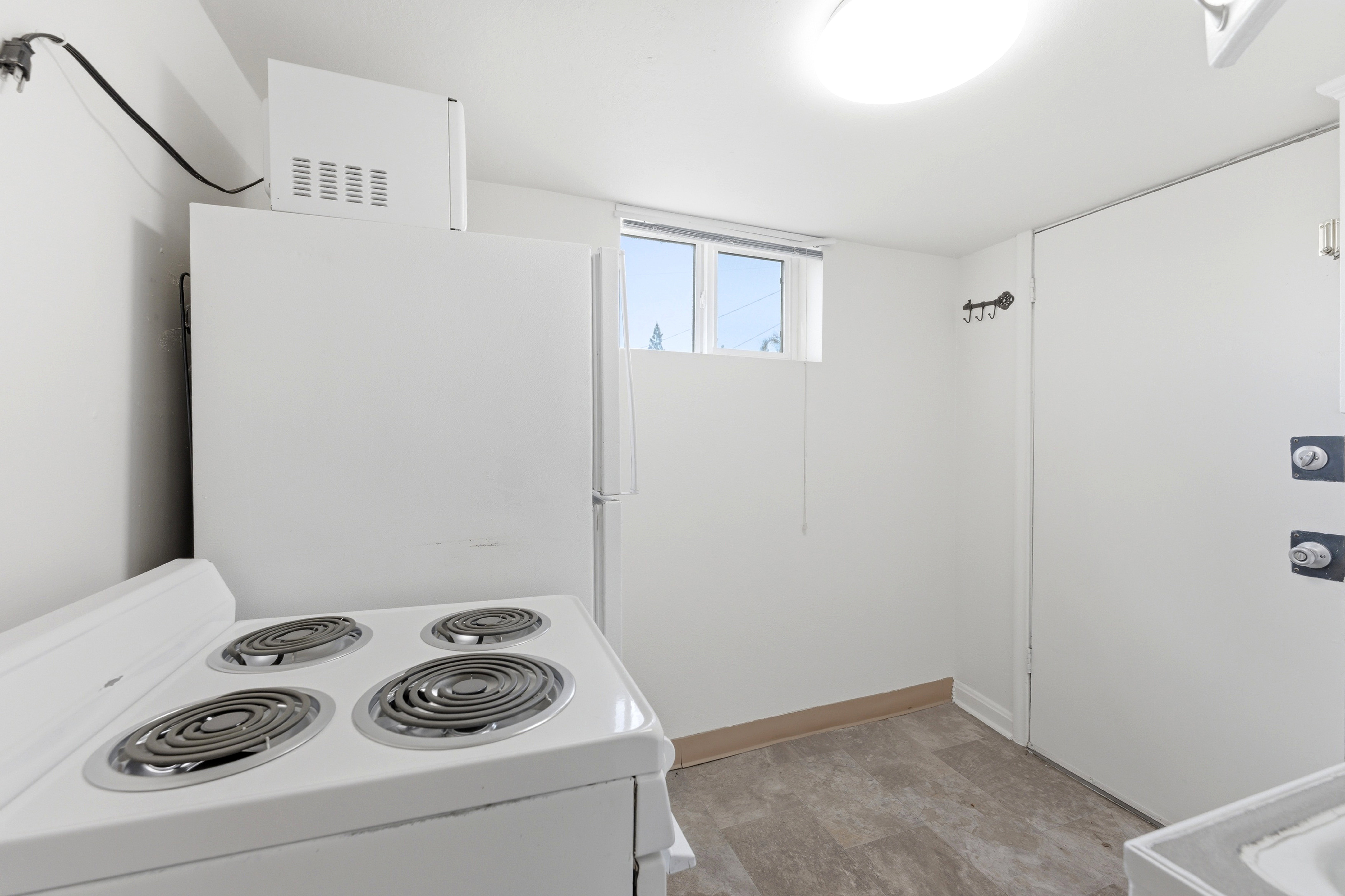 Kitchen featuring white appliances and white cabinetry