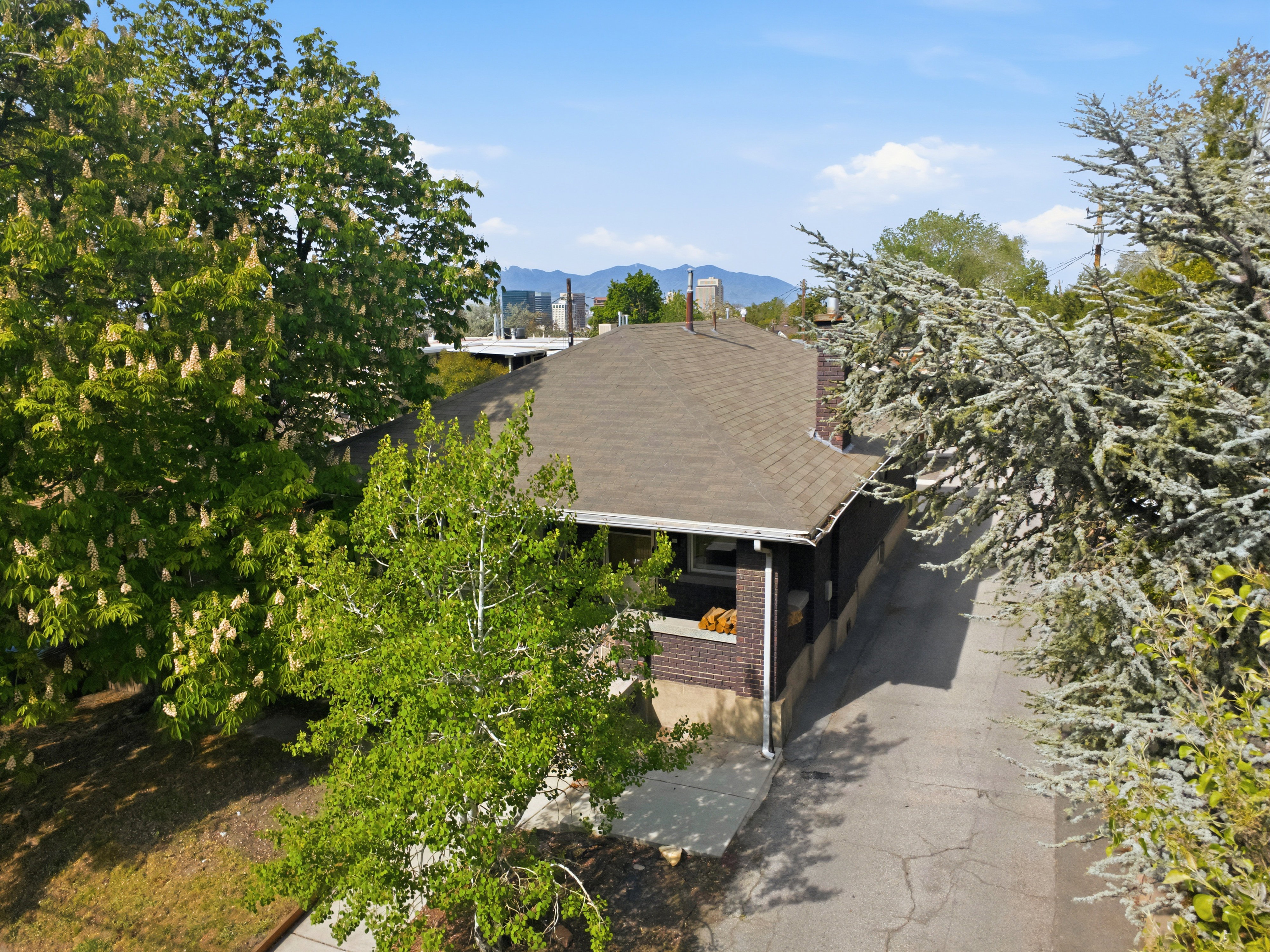 Aerial view of property and surrounding area featuring a mountain backdrop