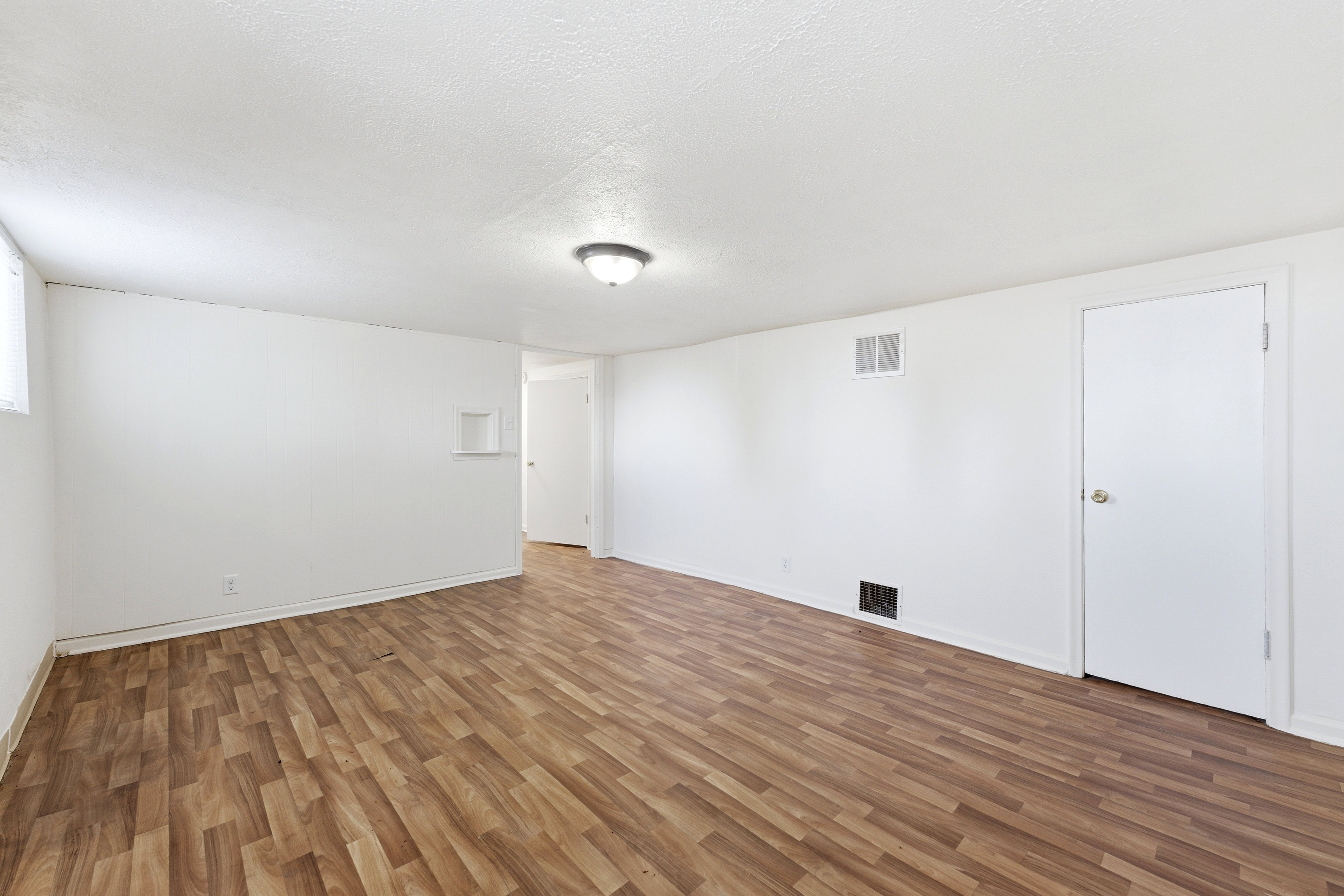 Unfurnished room with wood finished floors and a textured ceiling