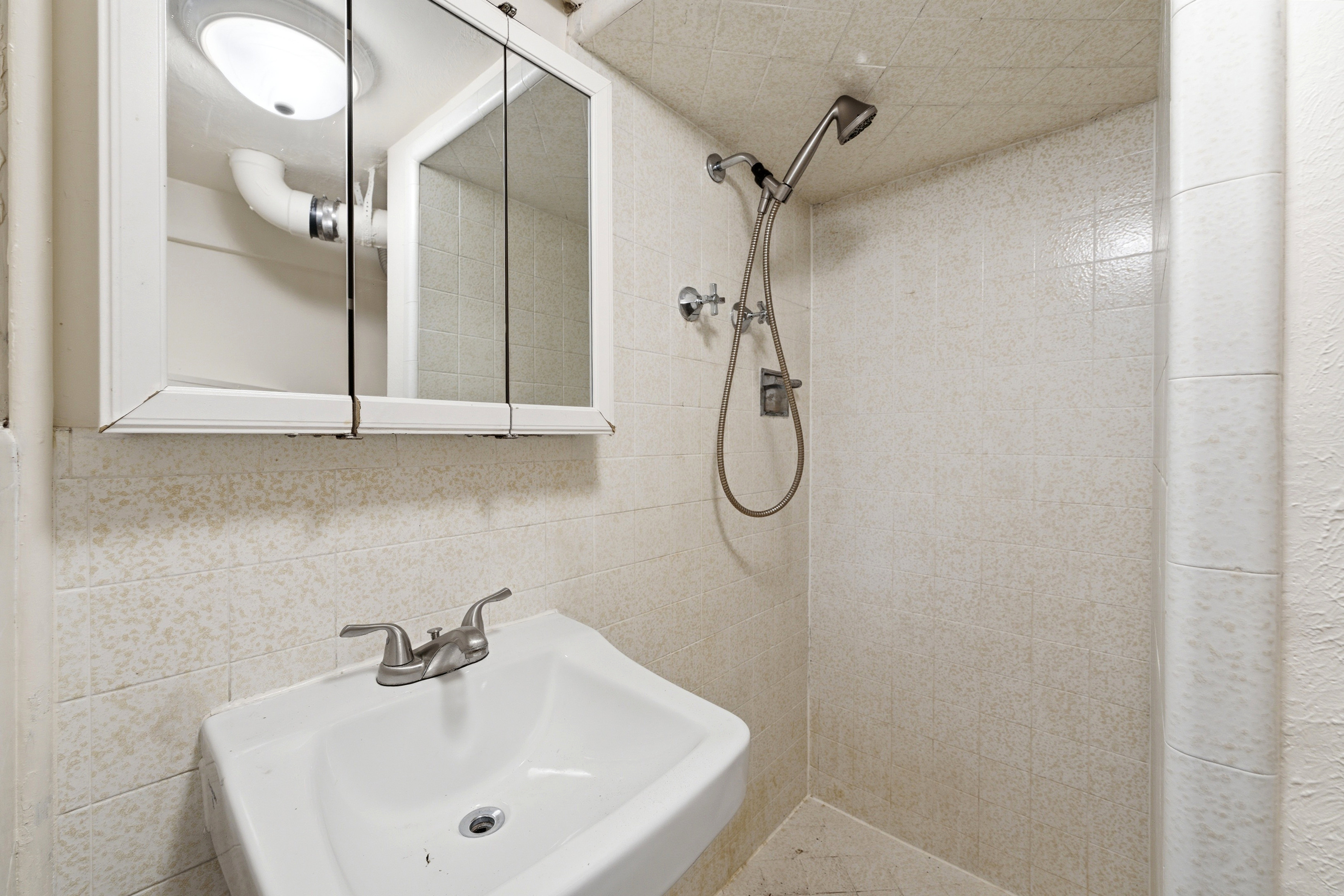 Bathroom with a shower stall and tile walls