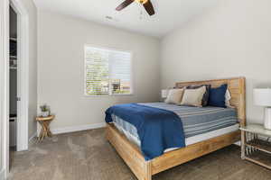 Carpeted bedroom with ceiling fan and baseboards