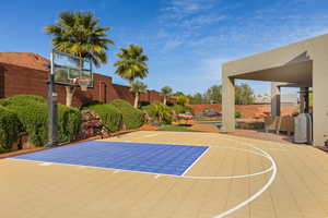 View of sport court featuring a fenced backyard, a patio area, and basketball hoop