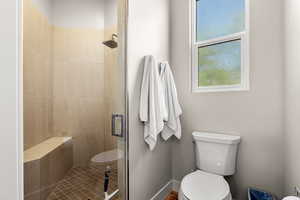 Full bath with toilet and a stall shower