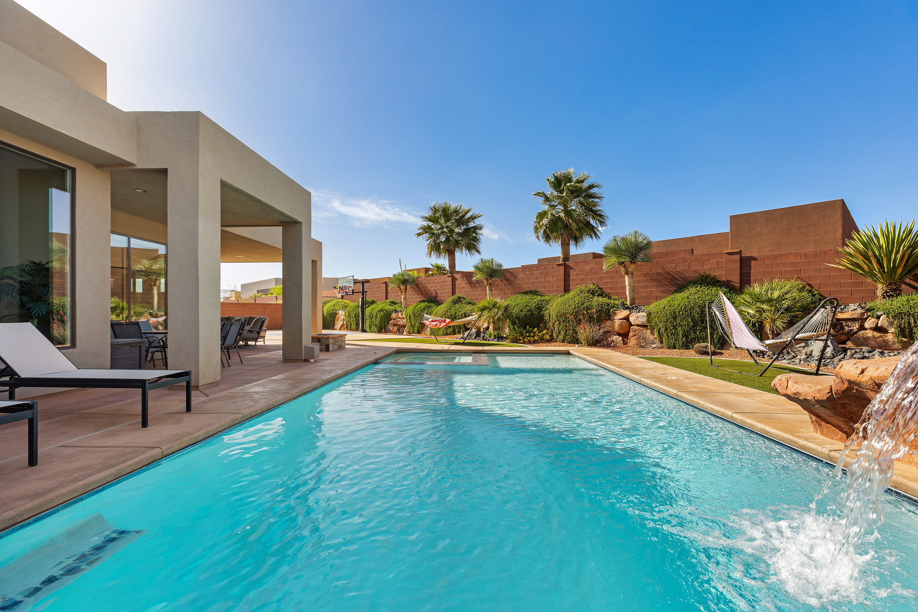 View of swimming pool with patio surround and a fenced backyard