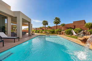 View of swimming pool with patio surround and a fenced backyard