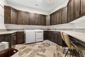 Laundry area with cabinet space and washing machine and clothes dryer