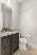 Half bathroom with vanity and baseboards