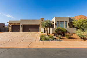 View of front of property with stone siding, an attached garage, stucco siding, driveway, and a mountain view