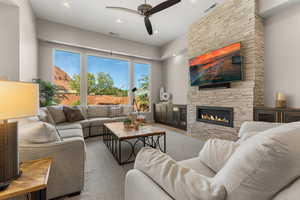 Living area with ceiling fan, a fireplace, and recessed lighting