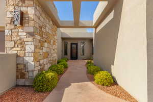 Entrance to property featuring stone siding and stucco siding