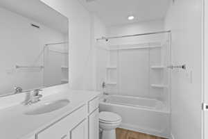 Full bathroom featuring vanity, light wood finished floors, and washtub / shower combination