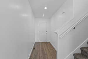 Corridor featuring dark wood-type flooring and recessed lighting