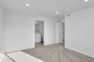 Unfurnished bedroom featuring light colored carpet, recessed lighting, and ensuite bathroom