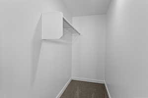Walk in closet featuring dark carpet